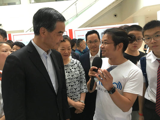 Incus explaining hearing aid technology to distinguished guest