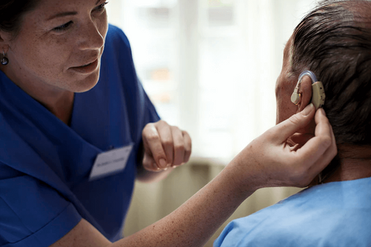 Man with permanent hearing loss being fitted with hearing aids