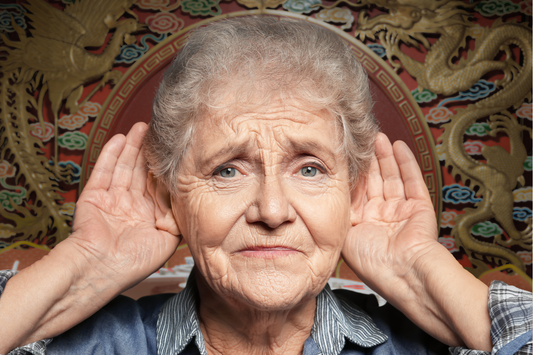 Woman experiencing sudden hearing loss, cupping ears in concern