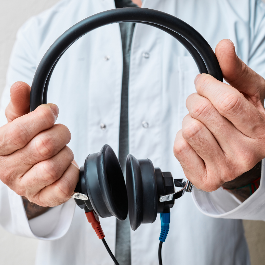Audiologist holding audiometer earphones